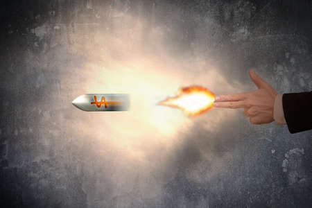 Hand of gun gesture with firelight shooting the dollar sign bulletの写真素材