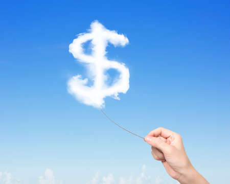 Woman hand pulling rope connected with dollar sign shape clouds in blue sky.の写真素材