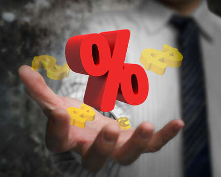 Business man hand showing 3D red percentage sign with golden dollar signs.の写真素材