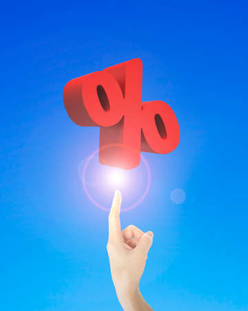 Human index finger pointing at 3D red percentage sign, on blue background.の写真素材