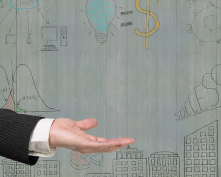 Empty open palm gesture of male hand with business concepts doodles on old green wooden wall background.の写真素材