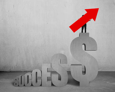 Man holding red arrow up sign, standing on concrete dollar sign with success text stairs, on concrete wall and floor indoors background.の写真素材