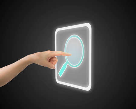 Female index finger touching search icon button, side view.の写真素材