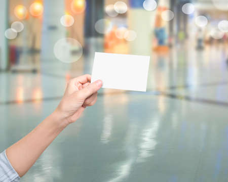 Womna hand holding blank white name card, on blurred backgroundの写真素材