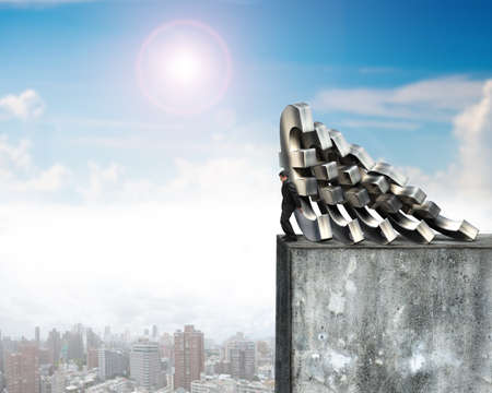 Businessman stopping the falling of Euro money on top of high concrete wall with sunny sky cityscape. Domino effect and problem solving of conceptsの写真素材