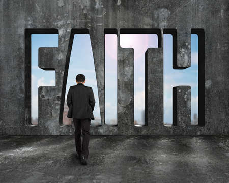 Faith word on concrete wall with man walking toward and view of sunny sky background.