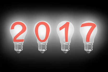 Bright 2017 light bulbs in a row illuminated the dark, with black background, 3D illustration.の写真素材