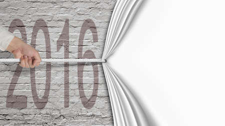 Human hand pulling blank white curtain covered 2016 on old brick wall background