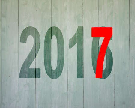 2016 to 2017, happy new year concept, on old wooden wall background.の写真素材