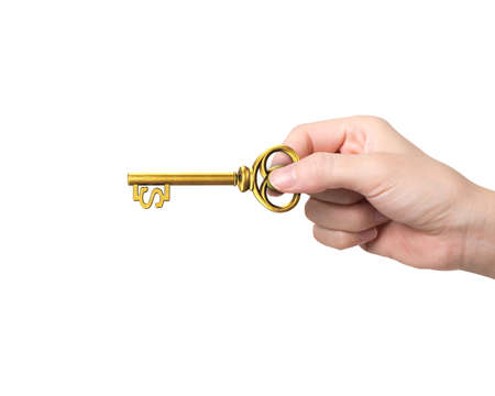 Hand holding golden treasure key in dollar sign shape, isolated on white background.の写真素材