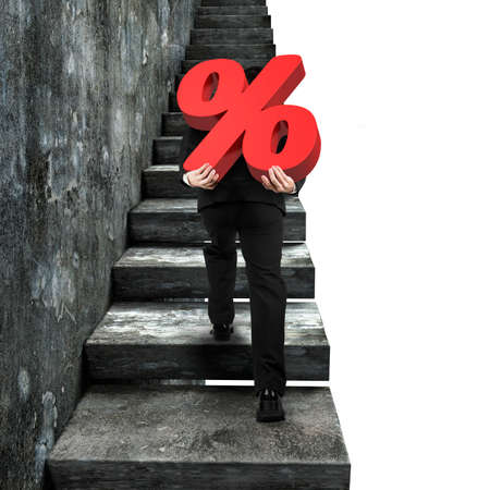 Man carrying red percentage sign climbing on old concrete stairs, isolated on white background.の写真素材