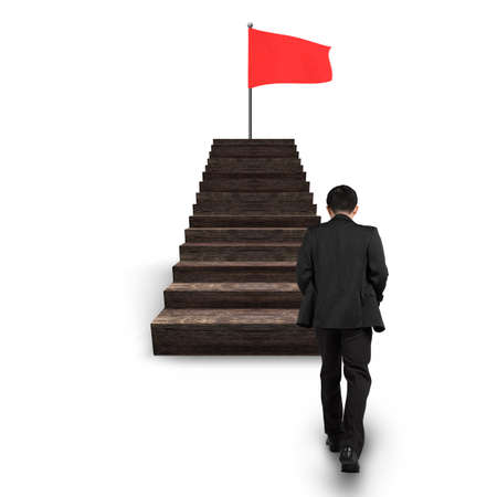 Man walking toward red wavy flag on top of wooden stairs, isolated on white background.の写真素材