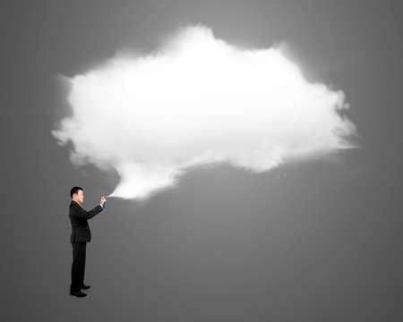 Man spraying out white cloud above his head, isolated on gray background.の写真素材