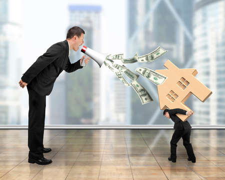 One man using megaphone spraying out dollar bills, yelling at another man carrying 3D wooden house.の写真素材