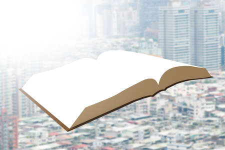 One book flying over city buildings background.の写真素材