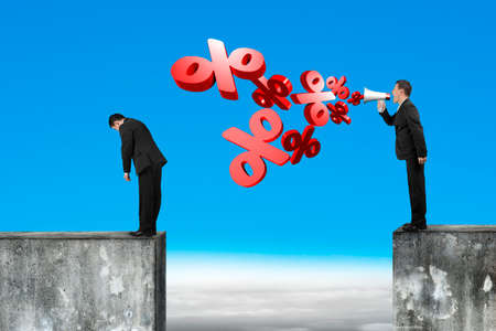Boss using megaphone yelling at the tired employee with spraying out 3D percentage marks, on top of high concrete wall and blue sky clouds background.の写真素材