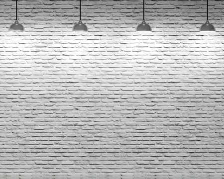 Brick wall and four ceiling lamps with white lightの写真素材