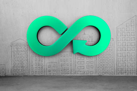 Circular economy concept. Green arrow infinity symbol on city buildings doodles concrete wall background.の写真素材