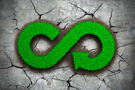 ECO and circular economy concept. The green grass in form of arrow infinity recycling symbol on dry...