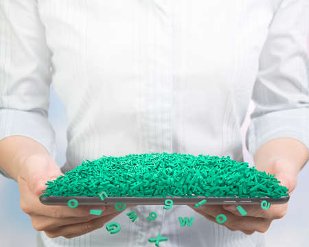 Big data concept. Woman hands holding smart tablet with huge amount of green letters and numbers,...