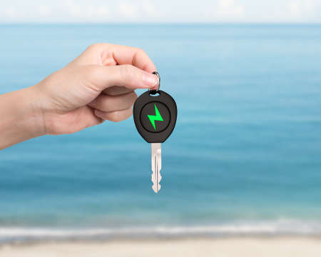 Green energy electric car and Eco-friendly environmental protection concept. Woman hand holding...