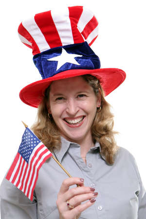 Patriotic lady waving a small American Flag and wearing a patriotic hat isolated against a white background.の写真素材