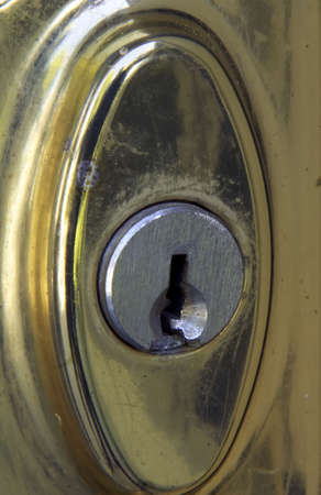 Old brass door lock, tarnished and weathered.の写真素材