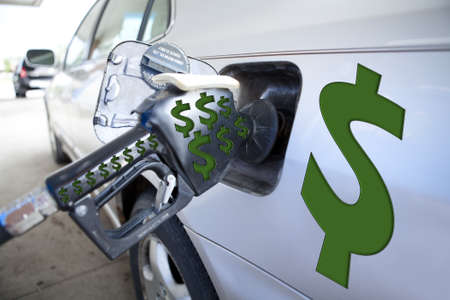 Automobile refilling at the pump with $$$ representing high costs.の写真素材