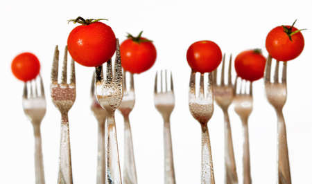 Water sprayed forks with cherry tomatoes with white background. の写真素材