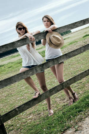Two beautiful young ladies are posing at paddockの写真素材