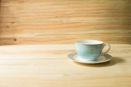 Place the empty coffee cup on a wooden table.
