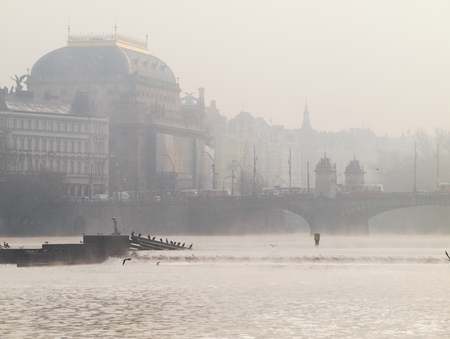 The National Theatre in Prague in the morning mist standing over the sluice on the River Vltava with waterfowl. Legion Bridge with standing trams.のeditorial素材