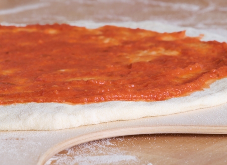 Sugo souce on raw pizza lying on the wooden pizza peelの写真素材