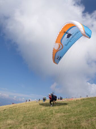 MALCESINE, ITALY â AUGUST 27  2019: Tandem paragliding on Monte Baldo above Lake Garda in the Garda Mountains in the Eastern Alps.のeditorial素材