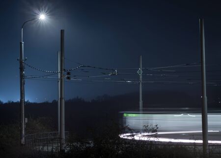 Night shot of tram terminal station of Barrandov housing estate with passing tram number five. In the background is visible diffuse glow of street lighting.の写真素材