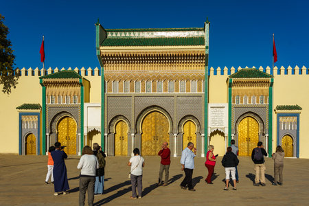 Morocco. Fez. A tourists in front the royal palace founded by the Merinids in 1320. It opens onto the Place des Alaouites through huge doors chiseled in copper made by a local craftsman around 1970.のeditorial素材