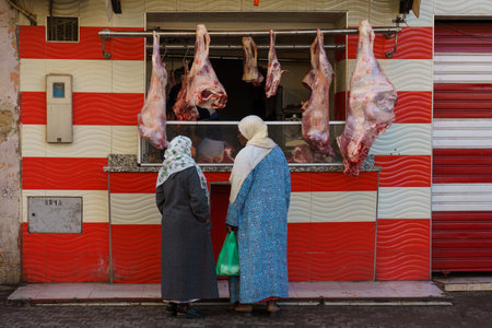 North Africa. Morocco. Taroudant. Two women in traditional dress in front of a storefront of a butcher's shopのeditorial素材