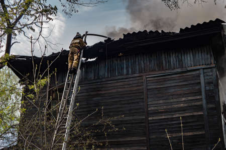 Firefighters extinguished the fire at an old house caught fireの写真素材