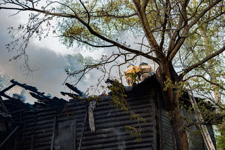 Firefighters extinguished the fire at an old house caught fireの写真素材