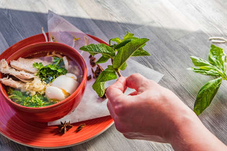 Delicious oriental soup in a red bowlの写真素材