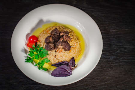A tasty dish of rice on a plate. On a wooden backgroundの写真素材