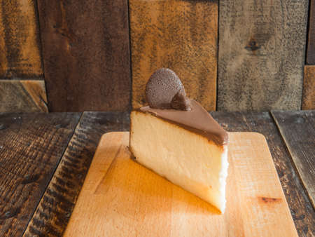 Tasty cheesecake on a wooden board in a cafeの写真素材