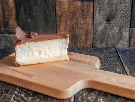 Tasty cheesecake on a wooden board in a cafeの写真素材