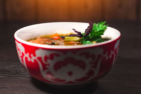 A plate of hot oriental soup with meat and noodlesの写真素材