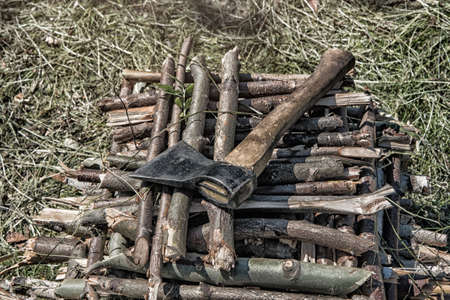The ax lies on wooden sticks on a summer dayの写真素材