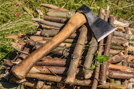 The ax lies on wooden sticks on a summer dayの写真素材