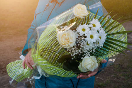 A bouquet of white flowers in the hands of a girlの写真素材