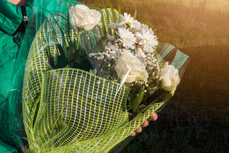 A bouquet of white flowers in the hands of a girlの写真素材