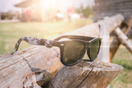 Sunglasses on a wooden log, a summer sunny dayの写真素材