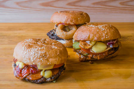 Juicy fresh burgers with a meat chop. Hamburger, cheeseburger, with tomato and salad and knifeの写真素材